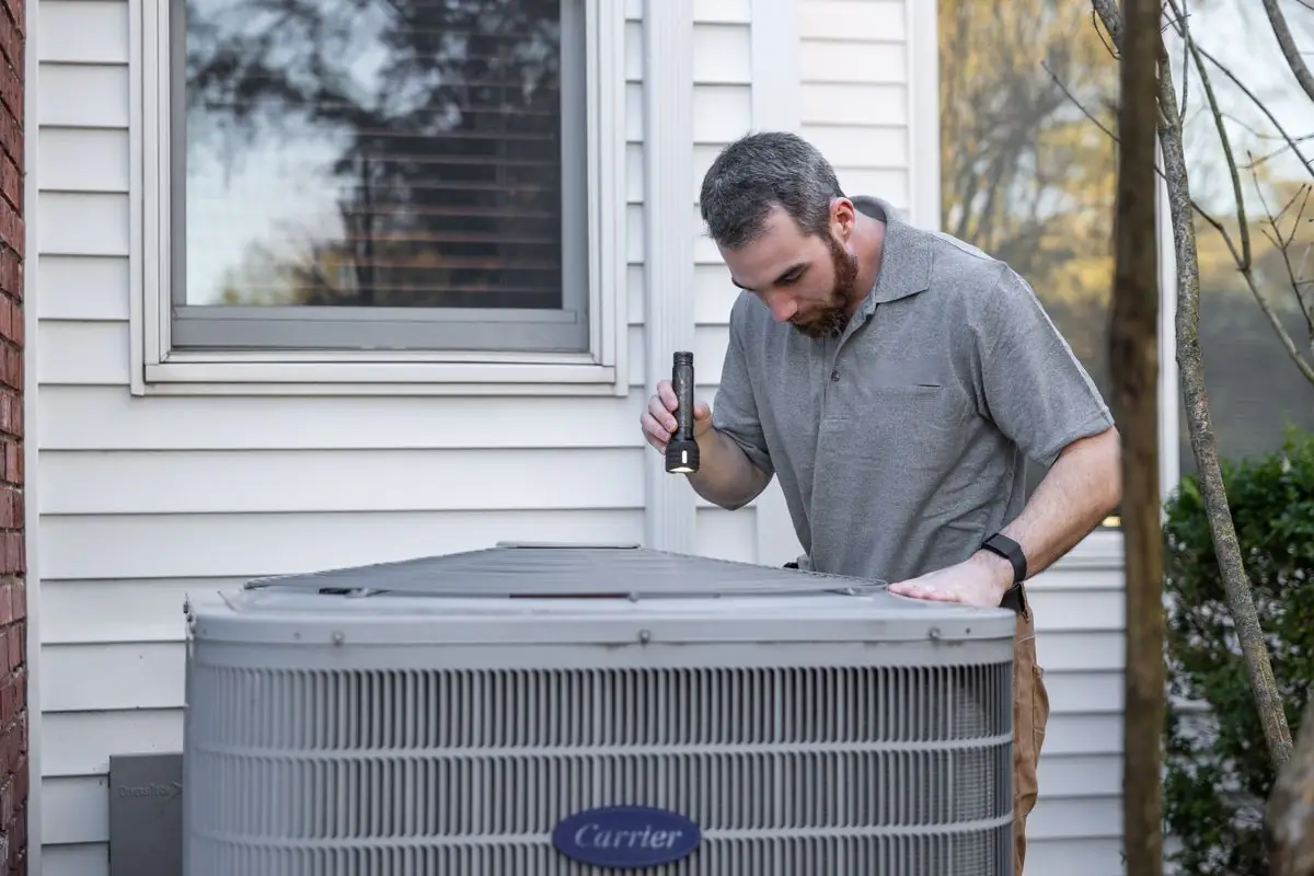 HVAC technician checking an outdoor condenser unit